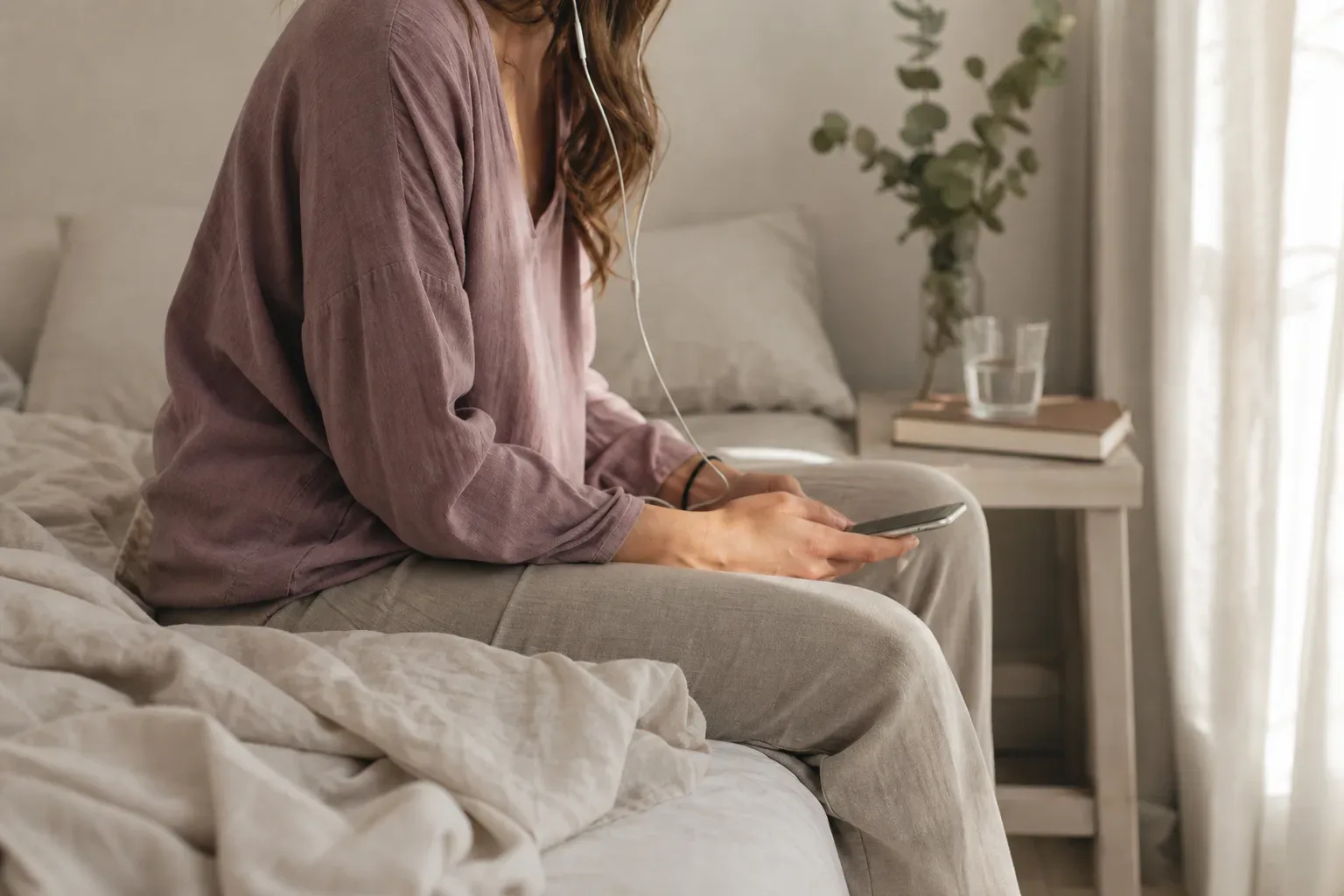 Person resting with headphones in soft morning light