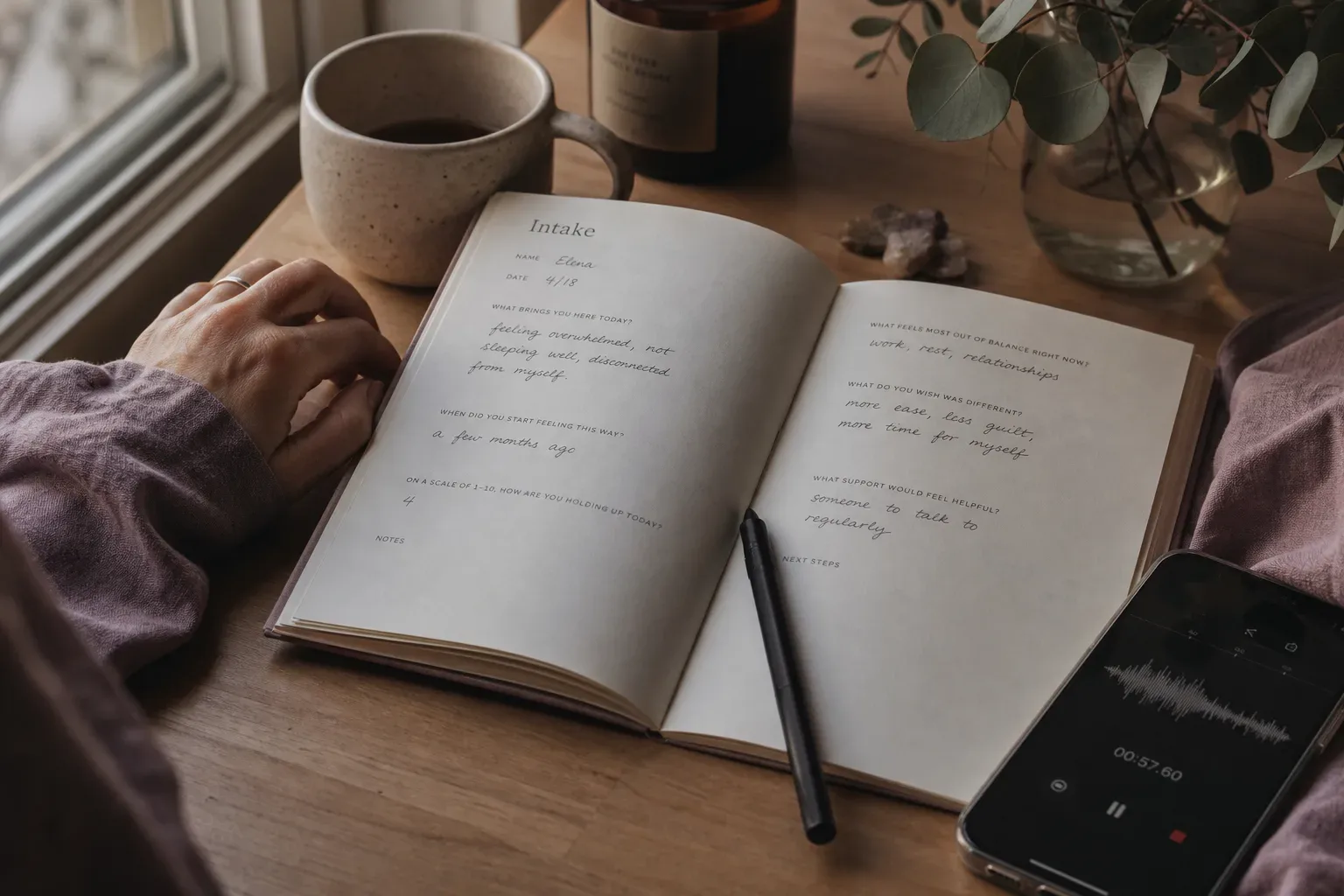 Notebook and phone beside a quiet morning window