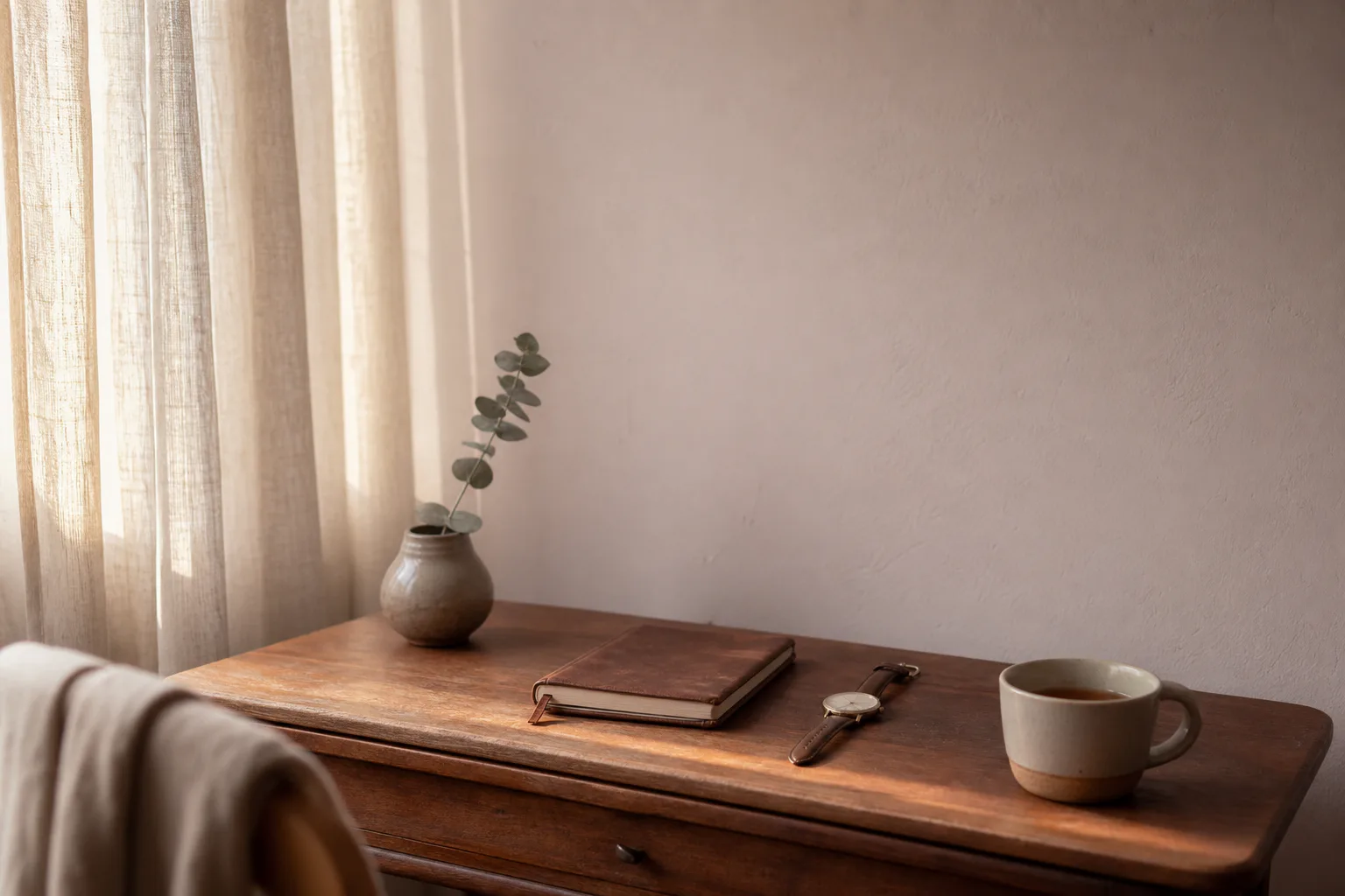 Soft interior with linen curtains, a quiet desk, and warm afternoon light.